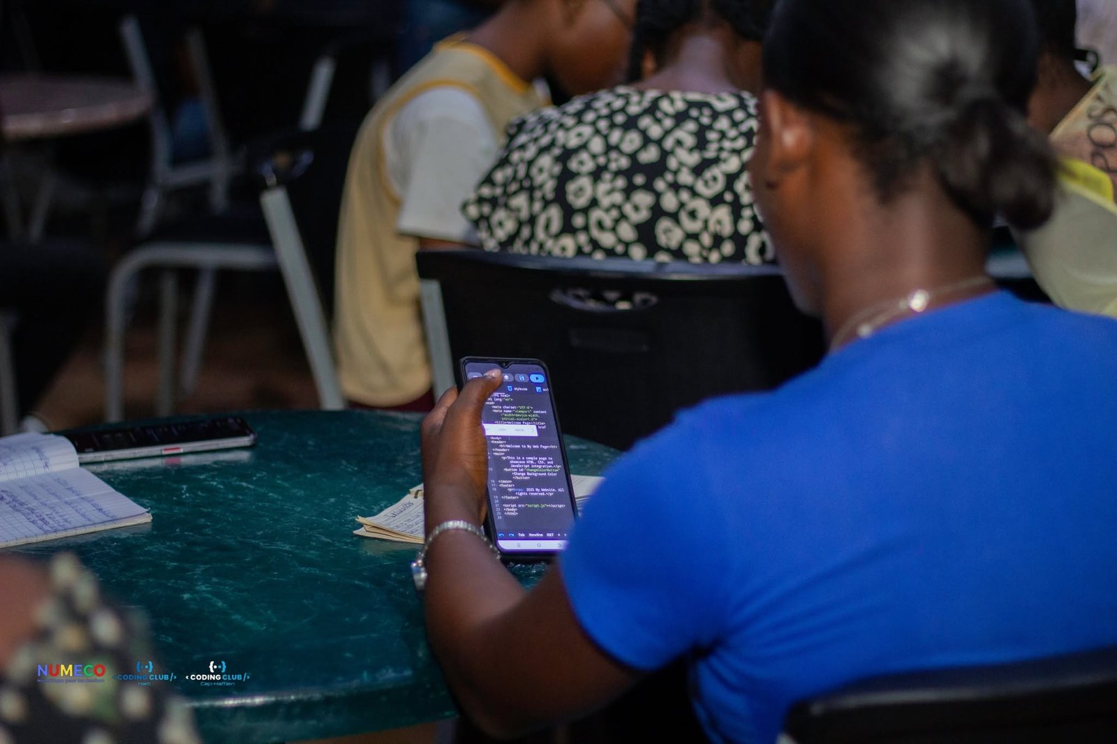 Élève suivant une session de code depuis un téléphone